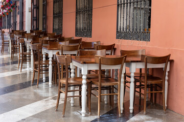Empty cafe with wooden tables and chairs arranged neatly, showcasing inviting atmosphere for tourists seeking relaxation and enjoyment
