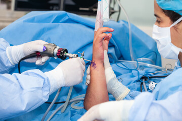 Group of surgeons performing an orthopedic surgery. Female doctor performing a surgery. Orthopedic...