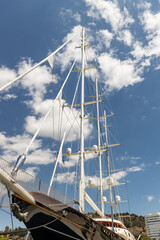 Tall sailing ship with white sails and rigging against a bright blue sky, showcasing nautical...