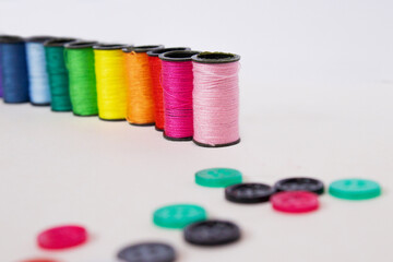 Sewing kit on white background: threads, needles, measuring tape, buttons, and fabric. Ideal for hobby sewing, fashion design, and clothing industry visuals.