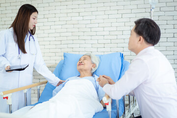 Obraz premium Asian man visiting his elderly mother in hospital and they have a conversation together.