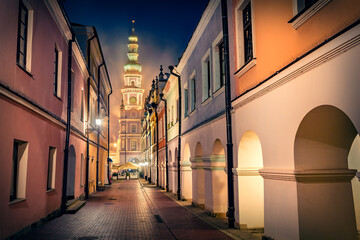 Misty summer view of colorful buildings and spire of town hall on background. Amazing morning cityscape of Zamosc, Poland, Europe. Traveling concept background.