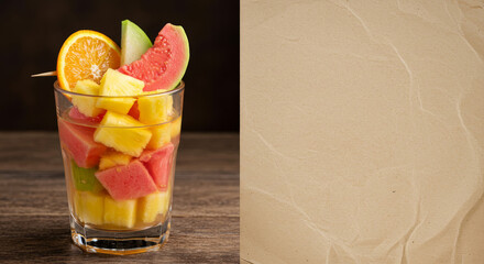Healthy exotic fruit mix with colorful straws in glass. Neutral background with copy space, perfect for ad layouts.