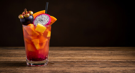 Healthy exotic fruit mix with colorful straws in glass. Neutral background with copy space, perfect for ad layouts.
