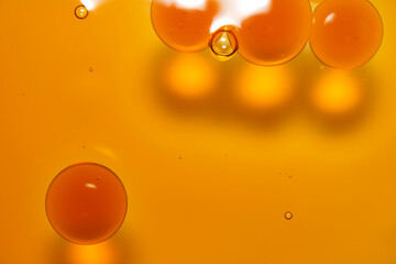 Vibrant Orange Liquid with Bubbles and Droplets in Close-Up View