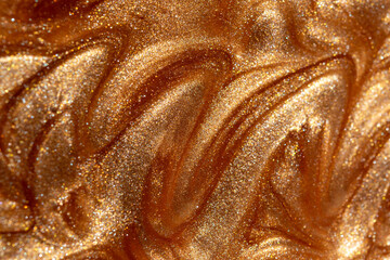 Glowing golden shimmering cosmetic texture of gel or body spray. Background texture for backdrops or mapping.