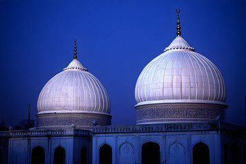 Fototapeta premium Twilight view of illuminated mosque domes with crescent finial