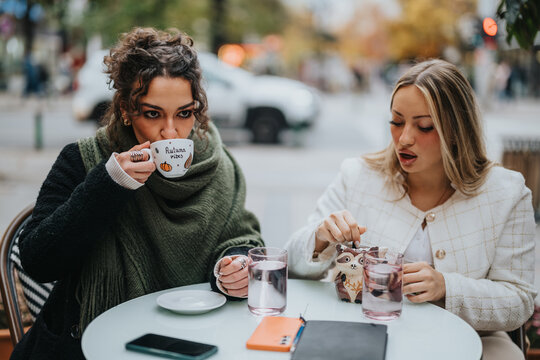 Two friends relaxing at an outdoor café, sipping drinks and sharing a cozy moment. Capturing the warmth, friendship, and comfort during a refreshing and informal coffee meeting in a relaxed
