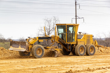 Motor grader on a construction site. Road construction.