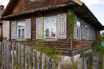 A house with a wooden fence and shutters on the windows