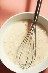 Protein coctail yellow beige colored with berry pieces. The process of making a cocktail with a steel whisk