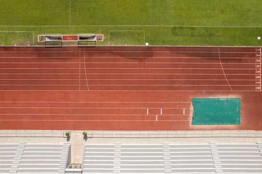 Aerial view of the Manuela Machado Municipal Stadium in Viana do Castelo, Portugal. Eight empty red tracks for running sports with tartan track of synthetic rubber on the athletic stadium.