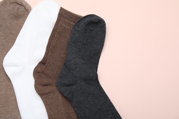 Many different pairs of socks on beige background, flat lay
