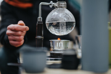 Detailed image depicting the process of brewing coffee using a siphon outdoors during a winter mountain picnic.