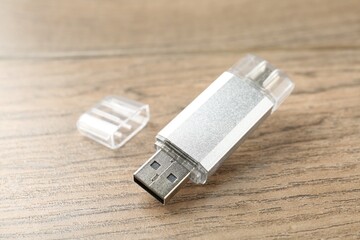 One flash drive on wooden background, closeup