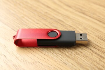One flash drive on wooden background, closeup