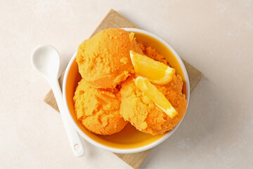 Tasty orange sorbet, fresh fruit and spoon on light table, top view