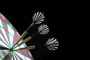 Targeting. Dart board with arrows on black background, closeup. Space for text