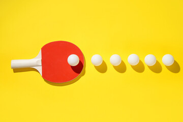 Ping pong racket and balls on yellow background, flat lay