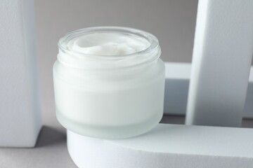 Stylish presentation of body cream in jar on light grey background, closeup