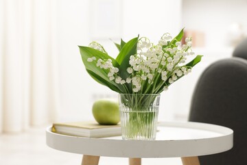 Bouquet of beautiful lily-of-the-valley on coffee table indoors