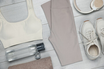 Sportswear, sneakers, water bottle and towel on floor, flat lay
