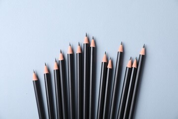 Many sharp graphite pencils on light grey background, flat lay