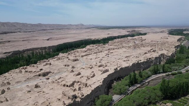 Turpan, China: Aerial drone footage of the ruins of the famous Jiaohe ancient city in Turpan that dates back to more than 2000 years in Turpan in China. Shot with a tilt down motion