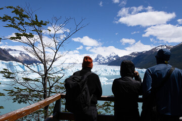 Tourists with unrecognizable backs admiring the Perito Moreno glacier