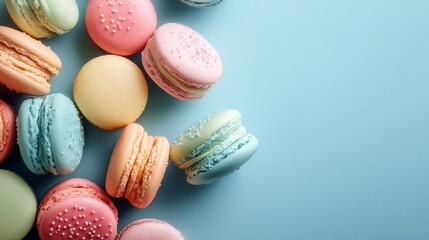 Fototapeta premium Delightful macarons scattered on a pastel blue backdrop perfect for sweet confections and dessert designs