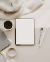 Arrangement of tablet, beverage, spoon, and writing tools on a soft neutral backdrop in calm morning light