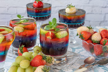 Homemade layered rainbow fruit jelly with fresh fruit