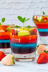 Homemade layered rainbow fruit jelly with fresh fruit