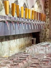 Row of beer taps,behind the bar of a small craft beer establishment.