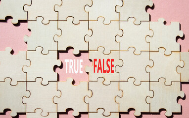 True or False symbol. Concept word True or False on wooden puzzle. Beautiful pink background....