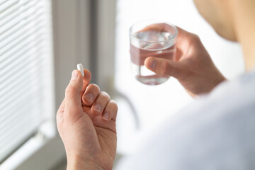 Close up of man's hands taking pill
