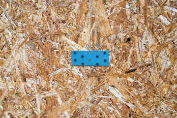 Two chipboard (DSP) panels joined with a metal bracket and screws, showcasing sturdy construction...