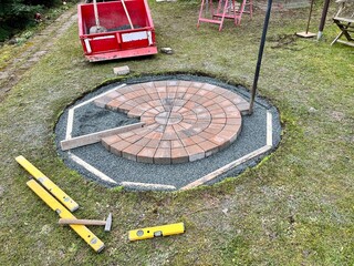 Einen Pflasterkreis legen als Feuerstelle im Garten