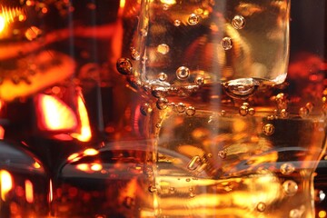 Refreshing cola with ice cubes as background, macro view
