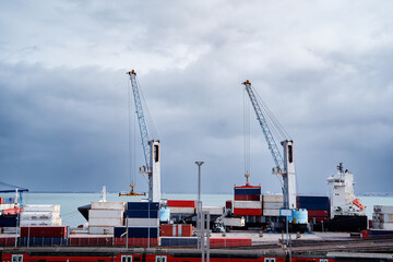 Large Commercial Port Scene With Cranes and Cargo Containers under Cloudy Sky..
