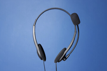 Headset with microphone in air on blue background