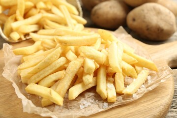 Tasty french fries on wooden table, closeup