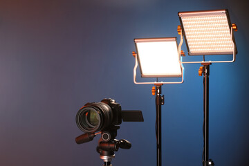 Professional lighting equipment and camera on color background. Space for text
