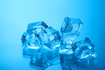 Cubes of clear ice on light blue background, closeup