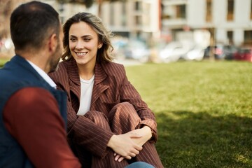 Smiling Couple Conversing Outdoors on Sunny Day in Urban Park