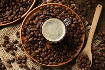 Aromatic coffee in cup and beans on table, flat lay