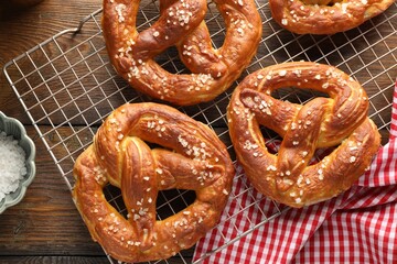 Tasty pretzels with salt on wooden table, flat lay