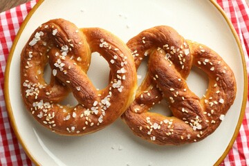 Tasty pretzels with salt on table, top view