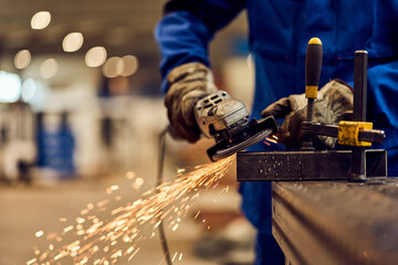 Worker Using Angle Grinder to Cut Metal with Sparks Flying