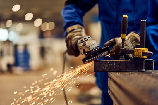 Worker Using Angle Grinder to Cut Metal with Sparks Flying
